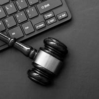 Photo d'un marteau de président posé sur un clavier d'ordinateur. Ceci est l’image des mentions légales du site professionnel du cabinet de Me Delphine Bracq. Avocate au Barreau de Lille, expertise en Droit de la Famille, Droit Civil Général et Droit du Travail